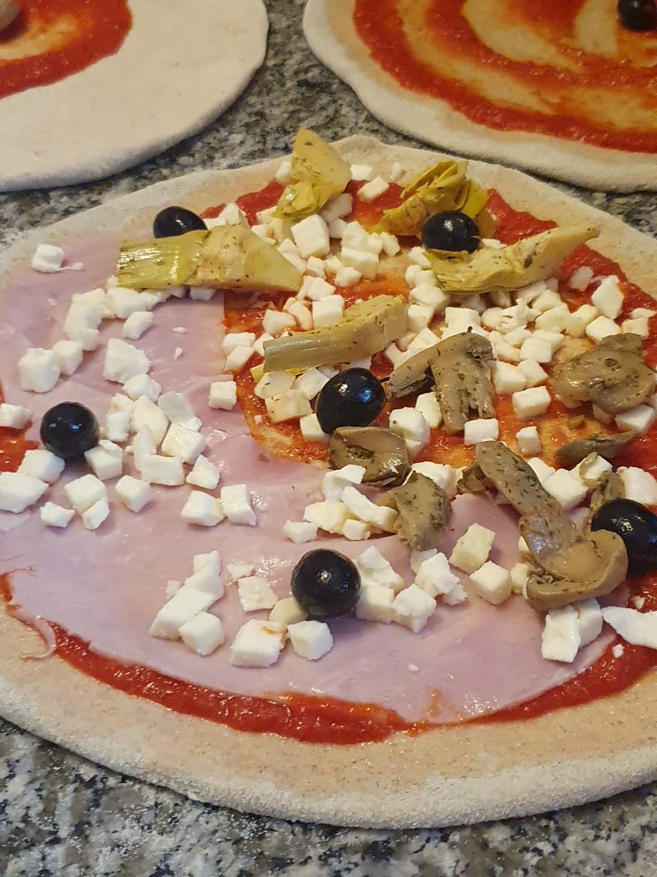 Basi pizza preparate al momento in una pizzeria d'asporto a Como